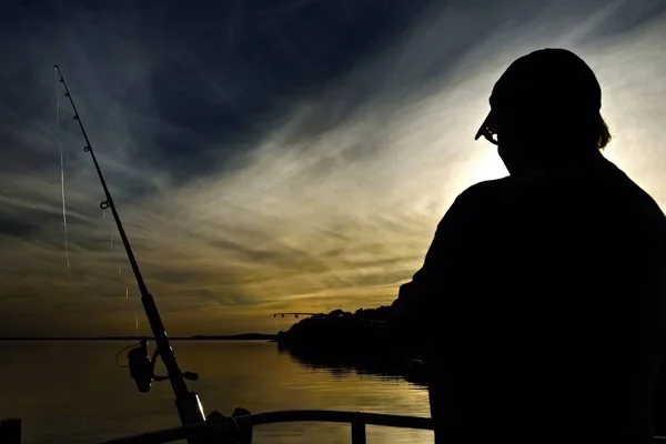 Silhueta de uma Lady Pesca ao pôr do sol — Fotografia de Stock