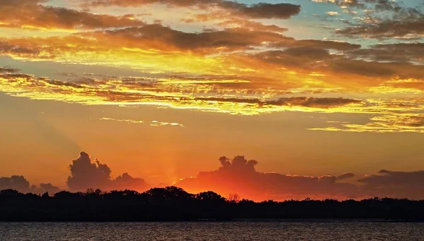 Sonnenuntergang mit hohem goldenen Glanz und purpurroten Akzenten und Silhouette — Stockfoto