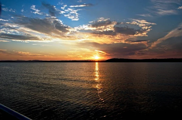 Lebendiges Gold und blauer Sonnenuntergang mit Wasserspiegelungen. — Stockfoto