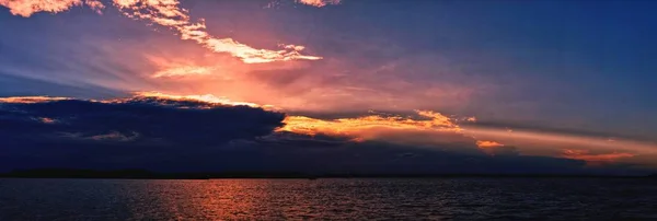 Vibrierende Ozean Sonnenuntergang Meereslandschaft durch Wolken und mit Wasser refle — Stockfoto