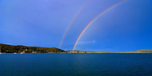 Mavi gökyüzünde muhteşem canlı çift Gökkuşağı Fotoğraf.