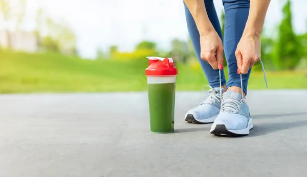 woman runner with green vegetable smoothie fitness and healthy lifestyle concept