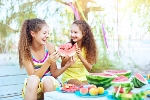 在阳光灿烂的日子里 快乐的女孩在海滩上吃西瓜 互相微笑 一起玩的开心夏天的概念时间 水果罐头 西瓜片放在桌上 — 图库照片