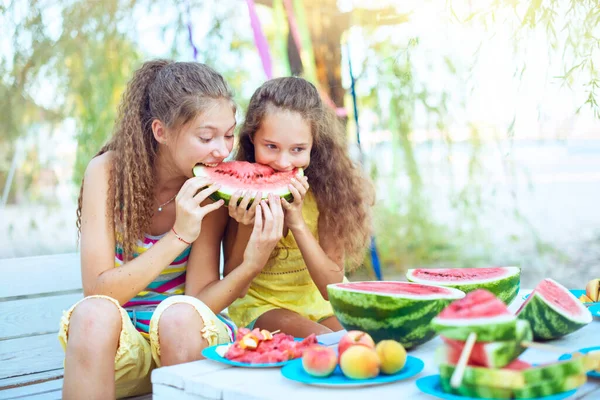 在阳光灿烂的日子里 野餐时快乐的朋友们一边吃着西瓜 一边互相微笑 一起玩的开心夏天的概念时间 水果罐头 西瓜片放在桌上 — 图库照片