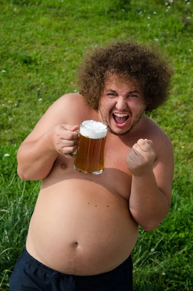 Толстяк пьет пиво. — стоковое фото