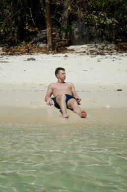 Yetişkin adam sahilde sunbathes