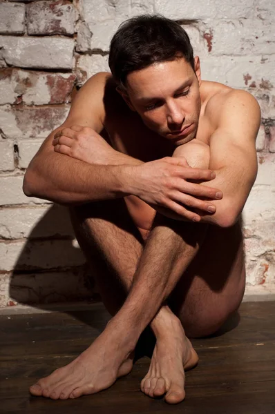 Desnudo sexy hombre se sienta y se siente triste . — Foto de Stock