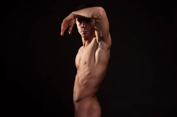 Sexy uomo nudo su uno sfondo nero . — Foto Stock