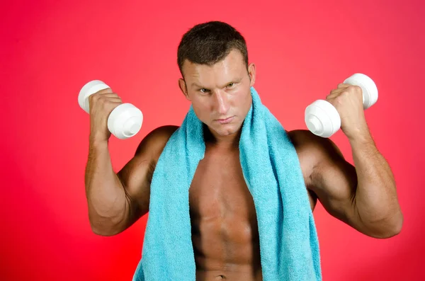 Personal trainer with dumbbells. Red background. — Stock Photo, Image