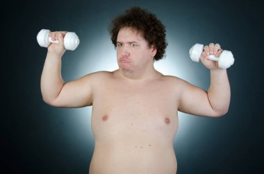 Eğitimden sonra. Ağır eğitim. Şişman adam dumbbells ile.