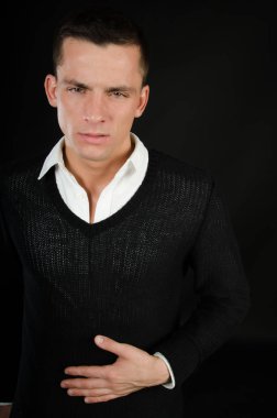 Acı ve keder. Üzgün genç adam. Stres, yorgunluk ve kas ağrısı. Genç adam onun mide tutuyor