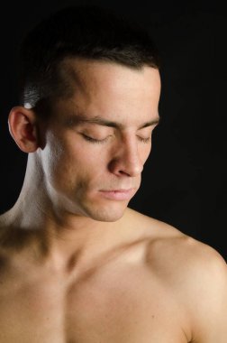 Güzel bir vücudu olan genç seksi adam. Atletik vücut siyah bir arka plan üzerinde poz ile model. Genç çekici adam.