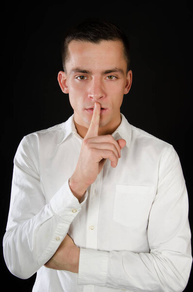 Shhhh. Man was silent. Black background. Keep silence. Attractive guy.