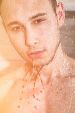 Duşta genç yakışıklı olan. Su, temizlik ve tazelik. Güneş, deniz ve tatil. Duşta seksi genç adam. Yakışıklı ve çekici. Erkeksi ve tabaklanmış