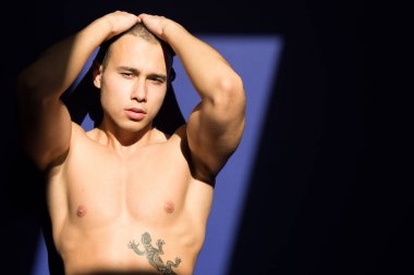 Genç çekici adam güneşin tadını çıkarıyor. Yaz ve tatil. Yaz ve güneş. Adam dinleniyor. Kas, yanık tenli ve seksi