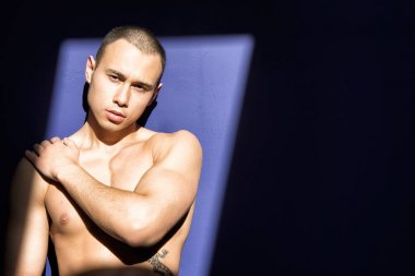 Genç çekici adam güneşin tadını çıkarıyor. Yaz ve tatil. Yaz ve güneş. Adam dinleniyor. Kas, yanık tenli ve seksi