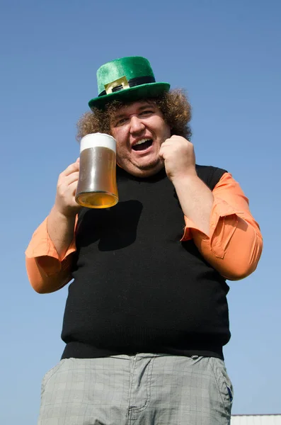 Funny fat guy is drinking beer.