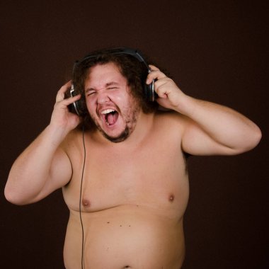 Komik şişman adam kulaklıkla müzik dinliyor..