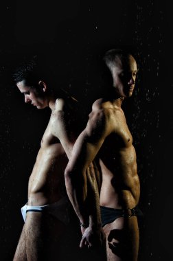 İki atletik ıslak adam. Sevgi. Siyah arkaplan.