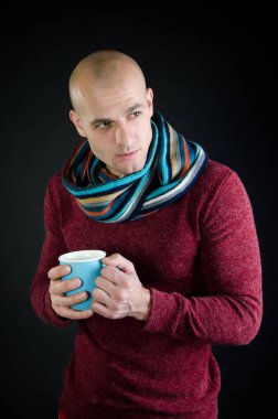 Genç çekici adam sıcak bir içki içiyor..