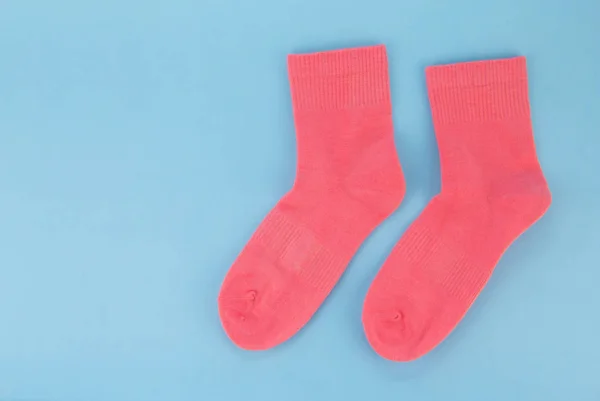 Розовые носки на синем фоне. Женские носки на цветном фоне — стоковое фото