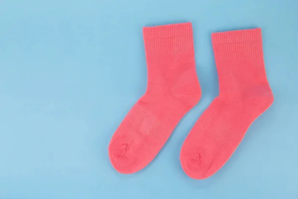 Chaussettes roses sur fond bleu. Chaussettes pour femmes sur un fond coloré — Photo