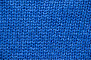 Yakından örgü örün. Renkli yün örgü, yakın plan. Mavi arkaplan