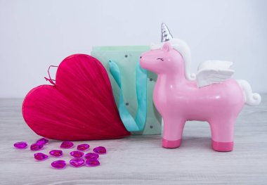 Sevgililer Günü için güzel bir hediye. Tek boynuzlu at ve kırmızı kalp hediye çantasının yanında.