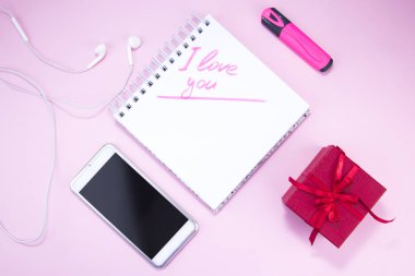 Hediye ve akıllı telefon pembe arka planda. Bir kadın için hediye. İşaretli yazı. Seni seviyorum. Dişiyi düzgünce stilize et..