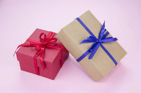 Gift with a blue and red ribbon on a pink background. Gift wrapping. Box with tape. — Stock Photo, Image