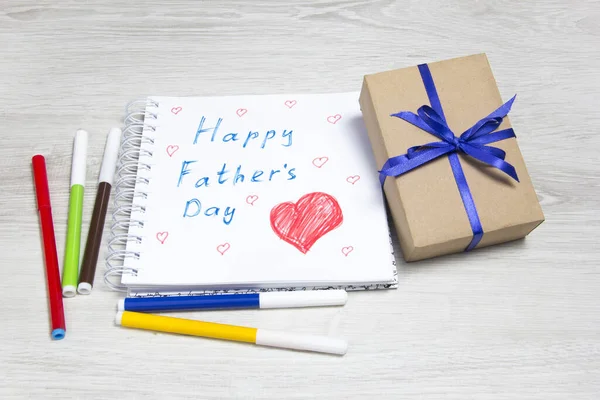 Pictures of father and son and gift box n blue background. Father\'s Day.