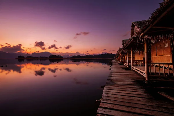 Khao Sok Ulusal Parkı 'nda yüzen bungalovlar Cheow Lan Gölü ve dağları ile birlikte gün doğumunda, Tayland.