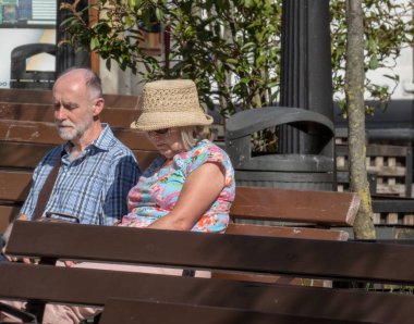 Laredo, İspanya, 28 Eylül 2019 Laredo caddesinde bankta oturan yaşlı çift, hüzünlü bir ifade.