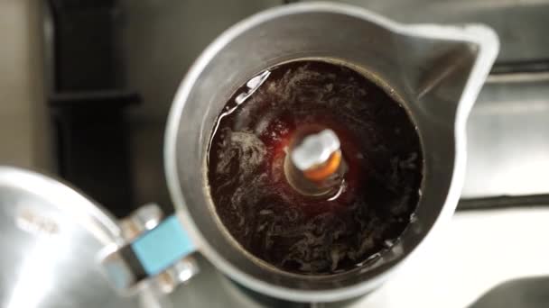 La cafetière de type Geyser brasse du café italien, vue de dessus. Le café remplit un bol de cafetière geyser. Faire un verre sous pression .