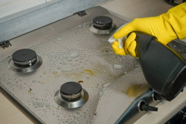 Bir insan gaz sobasındaki karmaşık kirleticileri temizler ve temizler..