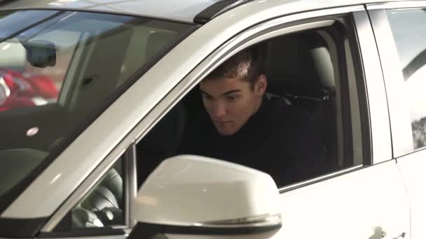 汽车经销商顾客买了一辆新车 他在为坐在车里的大拇指和钥匙做手势 — 图库视频影像