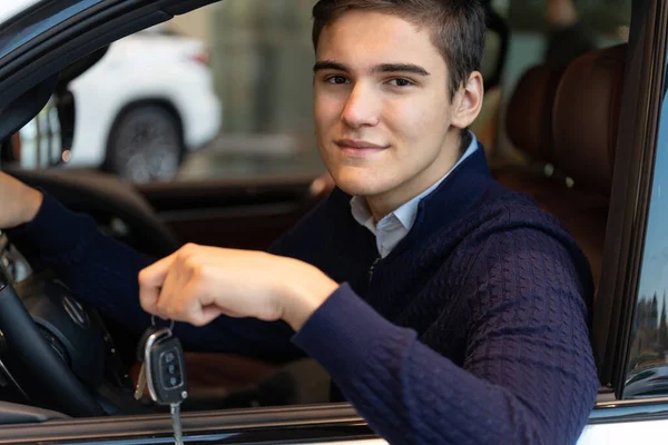 Cliente feliz en la sala de exposición del coche, que tiene la llave — Foto de Stock