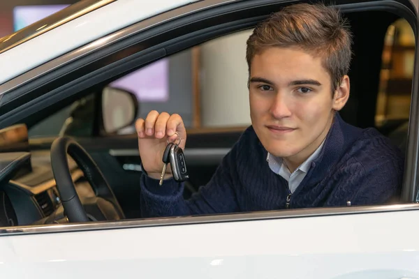 Las llaves en las manos del comprador de un coche nuevo. Negocio automovilístico, concesionario — Foto de Stock