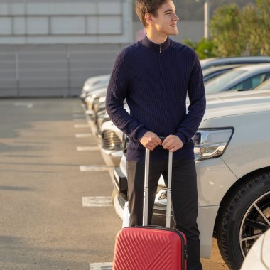 Seyahat eden genç adam transfer için bir araba seçiyor.