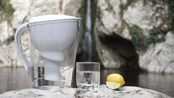 Filterjag Und Glas Reinen Wassers Mit Kalk Auf Dem Hintergrund — Stockvideo