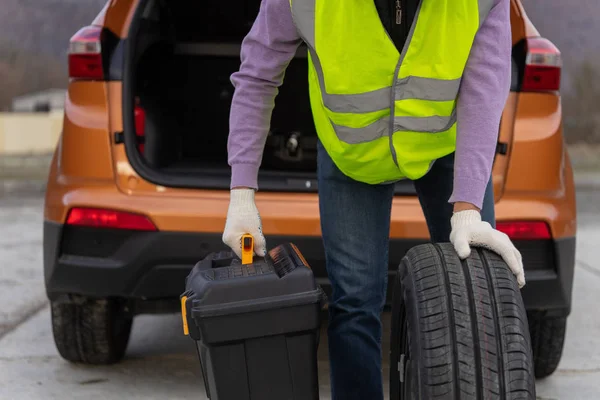 Begreppet att bära en hög synlighet eller hi-vis väst, under ett problem med en bil på vägen — Stockfoto