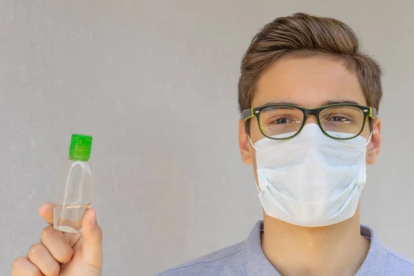 Retrato Joven Guapo Con Gafas Una Máscara Protectora Desechable Sosteniendo — Foto de Stock