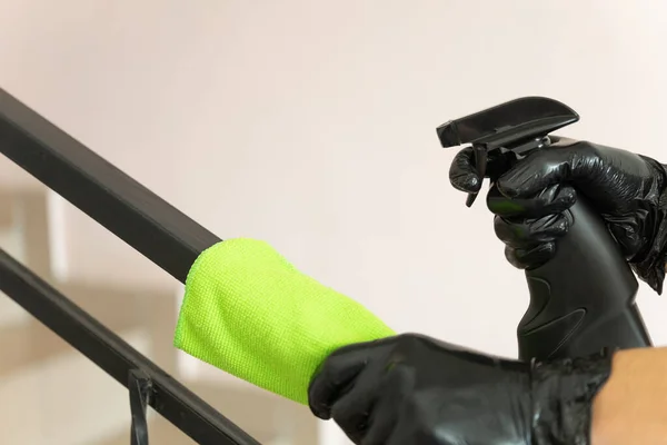 Cleaning and disinfecting public spaces during the Coronavirus pandemic 2020. Hands in rubber gloves wash the stairs with an antibacterial spray