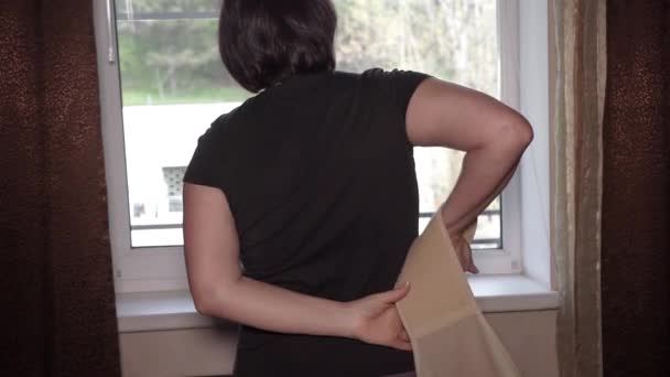 Dziewczyna Przy Oknie Zakłada Gorset Ortopedyczny Dolną Część Pleców — Wideo stockowe