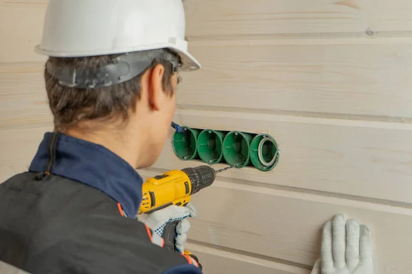 Een Elektricien Een Beschermhelm Gebruikt Een Boor Een Accuschroevendraaier Contactdozen — Stockfoto