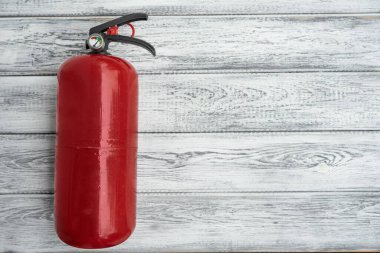 Hafif ahşap arka planda kırmızı bir el pudrası yangın söndürücü. Uzayı kopyala Üst Manzara. yangın güvenliği kavramları