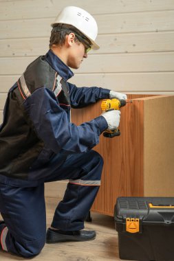 İç mekanda yeni masa kuran genç bir tamirci..