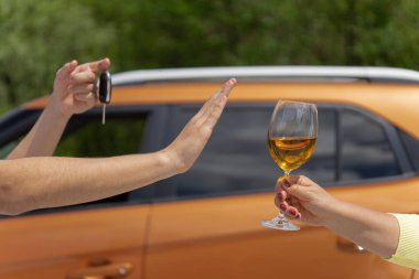 Hand refusing alcohol showing car key as gesture of don't drink. Designated driver clipart