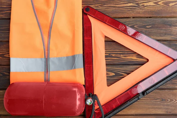 Red triangle road safety, a fire extinguisher and fluorescent reflective vest, top view