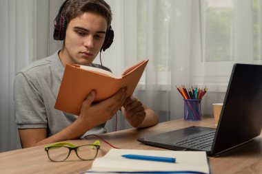 Bir genç internetten eğitim alıyor. Uzaktan eğitim seansları. Çevrim içi öğrenim